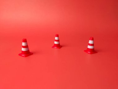 Kırmızı arka planda mini kırmızı plastik koniler