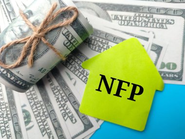 Banknotlar ve renkli not kağıdı. Mavi arkaplanda NFP kelimesi var..