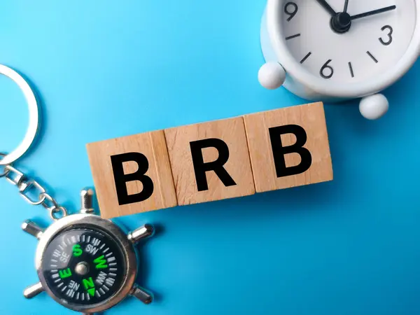 stock image Top view wooden block with the word BRB Be Right Back on a blue background.