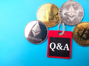 Üst görünüm altın bitcoin, gümüş ethereum ve mavi zemin üzerinde Q ve A yazılı renkli tahta.