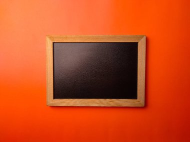 Üst görünüm siyah tahta tahtası turuncu arkaplan üzerinde kopya ve metin alanı.