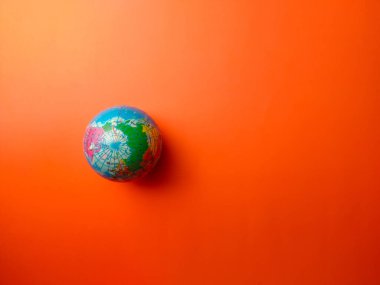 Turuncu arkaplandaki dünya küresi üzerinde kopya ve metin alanı.