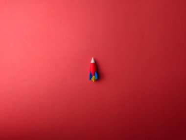 Kırmızı arkaplanda üst görünüm uzay roketi.