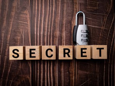 Asma kilit ve ahşap küp. Ahşap bir masa arkasında gizli bilgi var..