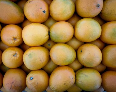 Bir süpermarkette düzgünce yerleştirilmiş portakal meyvelerinin üst görüntüsü.