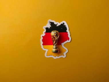 Perak, Malezya-23 Ağustos 2024: Sarı zemin üzerinde dünya kupası kupası bulunan Alman bayrağı etiketleri.