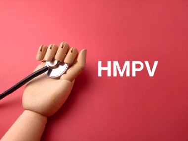 Tahta el ve HMPV sözcüğüyle steteskop kırmızı arka planda yeni bir virüs. Tıbbi ve sağlık konsepti.