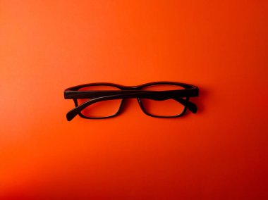 Turuncu arkaplanda siyah gözlük..