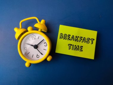 Alarm saati ve yapışkan notta mavi arkaplanda 