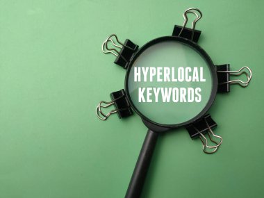 Yeşil arka planda HYPERLOCAL KEYWORDS sözcüğüyle büyüteç.