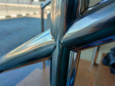 Resim, bir TIG Tungsten Inert Gas kaynak işlemi kullanılarak oluşturulmuş bir kaynak boncuğunun yakın çekimini görüntüler.