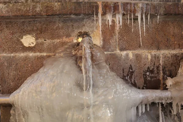 Erzurum in Turkey. Ancient water source (Turkish: Su Kaynak), close to Muratpasa mosque for ablution before prayer. Islamic ancient building, cold weather in winter -50 C. Snow, Freeze, ice