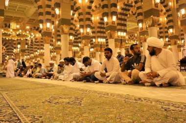 Medina, Saudi Arabia. Distributing free food to those who are fasting in the Prophets Mosque, tomb of the Prophet Muhammad. Food usually consists of dates, bread, water and milk clipart