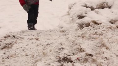 Soğuk bir kış gününde, buz tutmuş ve karla kaplı bir yolda yürüyen bir çocuk, buz üzerindeki ayak seslerinin çıtırtısıyla, dingin ve soğuk atmosfere canlı bir duyusal katman ekliyor.