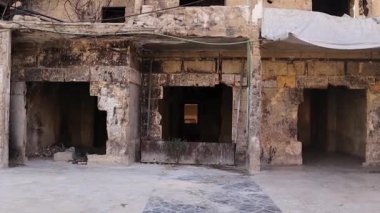 Suriye Halep 'teki ağır hasar gören bina, Esad' ın ordu bombardımanının yol açtığı yıkım izlerini taşıyor. Bu video yıkımı yakalıyor ve çatışmanın trajik etkisini vurguluyor.