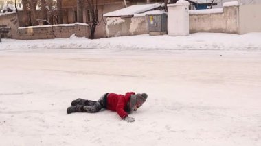 Çocuk karda neşeyle oynuyor, karla kaplı bir tepeye doğru koşuyor. Yarı yolda düştükten sonra, kararlılığını gösterir, ayağa kalkar ve tepeye tırmanır, ve neşeyle kahkahalarla güler. çocuklar