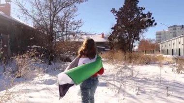 Genç kız, kendisi ve tüm Suriyeliler için daha parlak ve müreffeh bir gelecek umuduyla, omuzlarında Suriye Devrimi Bayrağı ile karda yürüyor..