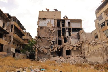 Halep, Suriye. Ağır hasar gören binalarda savaşın yol açtığı yıkım izleri var. Bu video yıkımı yakalıyor ve çatışmanın trajik etkisini vurguluyor.