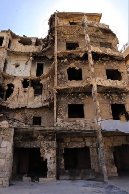 Halep, Suriye. Ağır hasar gören binalarda savaşın yol açtığı yıkım izleri var. Bu video yıkımı yakalıyor ve çatışmanın trajik etkisini vurguluyor.