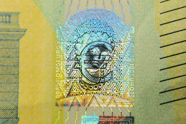 Lazer izi özelliğini gösteren 100 avroluk banknotun yakın plan görüntüsü. Lazer oymacılığı, sahtecilik ve sahtecilik karşıtı tedbirleri gösteren bir güvenlik özelliğini temsil ediyor..