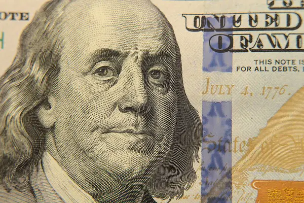 ABD Başkanı Benjamin Franklin 'in 100 dolarlık banknottaki portresine odaklanan yakın plan görüntüsü. Amerikan para birimi, finans ve zenginliğinin görsel bir temsili.