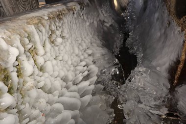 Erzurum 'daki antik bir taş su kaynağında (Türkçe: Su Kaynak) sersemletici buz oluşumları. Akan su eşsiz katmanlar halinde donar, sergilenen kışlar sert güzellik ve aşırı soğuk sanatlar sergiler..