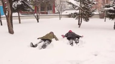 Çocuklar; erkek ve kız kardeşler kar yağıyor, kar melekleri yapıyorlar, kartopu atıyorlar, birbirlerini deviriyorlar, ve etrafta koşuşturuyorlar, büyülü kış atmosferinin ve çocukluk eğlencesinin tadını çıkarıyorlar.