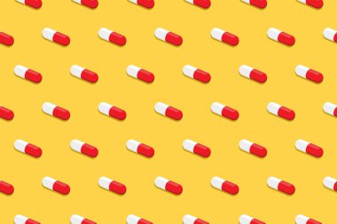Eczacılık ilaç hapları. Kapsül deseni sarı arkaplanda izole edilmiş. Tıbbın yaratıcı kavramı