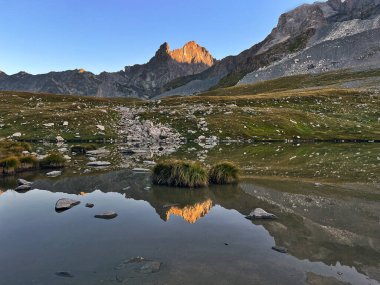 Sunrise Symphony: Peaks Panorama Lake in Vanoise National Park, Hautes Alps, France clipart