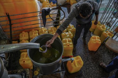 Zeytin eski yollara baskı yapıyor. 2 Kasım 2022, Gazze, Filistin: Gazze 'deki Filistinliler eski makineleri kullanarak zeytin basıyorlar, ve bu meslek atalarından miras kaldı ve bir gelir kaynağı olarak kabul ediliyor.