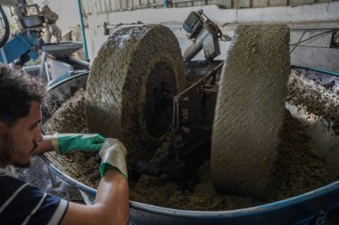 Zeytin eski yollara baskı yapıyor. 2 Kasım 2022, Gazze, Filistin: Gazze 'deki Filistinliler eski makineleri kullanarak zeytin basıyorlar, ve bu meslek atalarından miras kaldı ve bir gelir kaynağı olarak kabul ediliyor.
