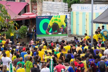 FIFA Dünya Kupası Katarı 2022: Taraftarlar Brezilya ve Sırbistan 'a eşlik etmek üzere Prainha Meydanı' nı doldurdular. 24 Kasım 2022, Rio de Janeiro, Brezilya: Taraftarlar, Brezilya takımının Sırbistan 'a karşı oynadığı maçı izlemek için Gamboa, Rio de Janeiro şehir merkezindeki Prainha Meydanı' nda toplandılar