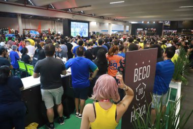 İzleyiciler ayrıca CCXP22 'de Brezilya ile Kamerun arasındaki maçı da izliyor. 2 Aralık 2022, Sao Paulo, Brezilya: CCXP 22 sırasında Katar Fifa Dünya Kupası G Grubu için Brezilya ile Kamerun arasında oynanan maçı da halk ekranlarda izlemektedir. 