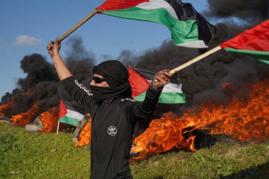 Palestinians demonstrate on the borders of the Gaza Strip. February 22, 2023, Gaza, Palestine: Palestinian youth set fire to rubber tires on the eastern borders of the Gaza Strip clipart