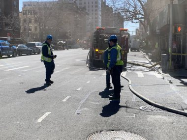 (İşteki itfaiyeciler elektrik sorunlarından dolayı yangını kontrol altına almaya çalışıyorlar. 16 Mart 2023, New York, ABD: İtfaiyeciler 9. Cadde ile 410 W 24. Cadde 'de elektrik sorunları nedeniyle yangını kontrol altına almaya çalışırken görüldü