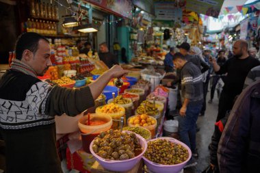 (Filistinliler alışveriş yapıyor ve Ramazan ayı için hazırlanıyorlar. 21 Mart 2023, Gazze, Filistin: Filistinliler Ramazan ayı için malzeme satın almak için marketlere giderler, örneğin evleri dekore etmek ve gıda satın almak için malzemeler.. 