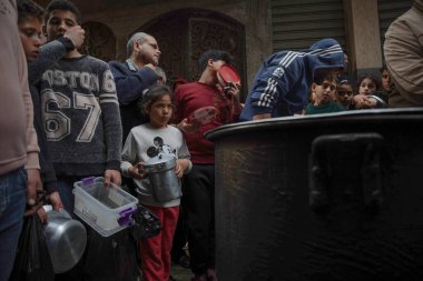 Filistinli Velid Al-Hattab çorba pişirir ve Gazze 'deki fakir ailelere dağıtır. 25 Mart 2023, Gazze, Filistin: Filistinli Velid Al-Hattab büyük bir kâsede çorba pişiriyor ve El-Shujaia 'daki fakir ailelere ücretsiz dağıtıyor. 