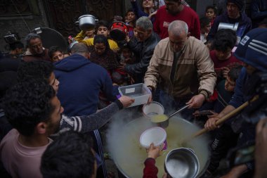 Filistinli Velid Al-Hattab çorba pişirir ve Gazze 'deki fakir ailelere dağıtır. 25 Mart 2023, Gazze, Filistin: Filistinli Velid Al-Hattab büyük bir kâsede çorba pişiriyor ve El-Shujaia 'daki fakir ailelere ücretsiz dağıtıyor. 
