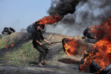 (Filistinli gençler Gazze Şeridi 'nin sınırlarında lastik lastikleri yaktılar. 5 Nisan 2023, Gazze, Filistin: Düzinelerce Filistinli genç Gazze Şeridi 'nin doğu sınırlarında lastik lastikleri yaktı