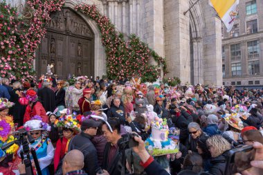 2023 New York City Easter Bonnet Parade. April 09, 2023, New York, New York, USA: People wearing costumes and lavishly decorated hats crowding on the steps of St. Patrick's Cathedral during the Easter Parade and Bonnet Festival 2023  clipart