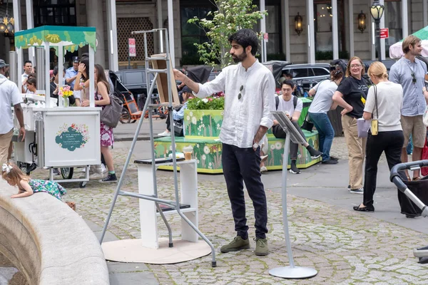 Stock image Fifth Avenue Blooms. May 13, 2023, New York, New York, USA: A student from New York Academy of Art paints during the Fifth Avenue Blooms imagined by Van Cleef event at Pulitzer Fountain on May 13, 2021 in New York City.   