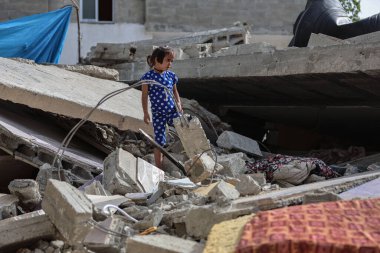 Filistinliler, İsrail işgal uçakları tarafından yok edilen evlerinin önünde oturuyorlar. 22 Mayıs 2023, Gazze, Filistin: Nabhan ailesinden Filistinliler, İsrail işgal uçakları tarafından yıkılan evlerinin enkazında oturuyorlar.