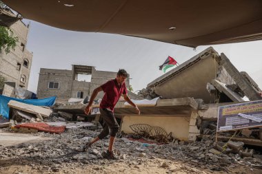 Filistinliler, İsrail işgal uçakları tarafından yok edilen evlerinin önünde oturuyorlar. 22 Mayıs 2023, Gazze, Filistin: Nabhan ailesinden Filistinliler, İsrail işgal uçakları tarafından yıkılan evlerinin enkazında oturuyorlar.