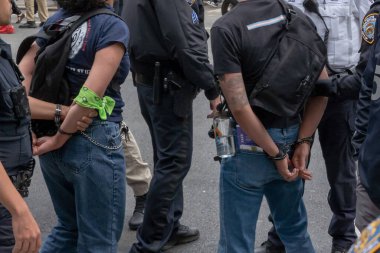 Belediye Başkanı Adam 'ın bütçe kesintilerini protesto etmek için düzenlenen mitingde ve yürüyüşte iki kişi tutuklandı. 24 Mayıs 2023, New York, New York, ABD: Tutuklu eylemciler, New York Polis Departmanı (NYPD) memurları tarafından protesto yürüyüşü ve yürüyüş için götürüldü 