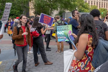İki kişi mitingde ve Mart 'ta Belediye Başkanı Adam & 39.' nun Bütçe Kesintisi 'ni Protesto Etmek İçin Tutuklandı. 24 Mayıs 2023, New York, New York, ABD: Eylemci, Başkan Adams 'a bir yürüyüş ve yürüyüş sırasında bütçe kesintilerini durdurması yönünde çağrıda bulunan pankartlar dağıtıyor 