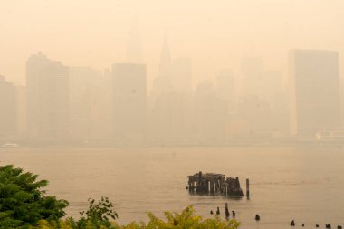 Kanada 'daki orman yangınlarından çıkan duman güneye doğru esiyor ve 7 Haziran 2023' te, New York, New York, ABD 'de New York City' nin gökyüzü alevler altında kalıyor. 