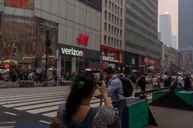 Kanada 'daki yangınlardan çıkan duman güneye doğru esiyor ve Doğu Amerika' nın Büyük Swath 'ında Puslu Koşullar yaratıyor. 7 Haziran 2023, New York, New York, ABD: Yayalara ait bir fotoğraf 34. Cadde üzerinde Orange Sun günbatımı Kanadalı orman yangınlarından çıkan ağır dumanlar gibi