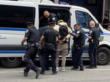 NYPD Time Meydanı 'ndaki yasadışı satıcıları tutukladı. 15 Haziran 2023, New York, ABD New York Polis Departmanı Times Meydanı 'nda iki şüpheliyi tutuklayıp yakınlardaki bir karakola götürürken yasadışı anlaşmaları temizlemek için tam güçte. 