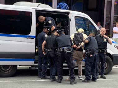 NYPD Time Meydanı 'ndaki yasadışı satıcıları tutukladı. 15 Haziran 2023, New York, ABD New York Polis Departmanı Times Meydanı 'nda iki şüpheliyi tutuklayıp yakınlardaki bir karakola götürürken yasadışı anlaşmaları temizlemek için tam güçte. 