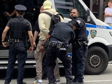 NYPD Time Meydanı 'ndaki yasadışı satıcıları tutukladı. 15 Haziran 2023, New York, ABD New York Polis Departmanı Times Meydanı 'nda iki şüpheliyi tutuklayıp yakınlardaki bir karakola götürürken yasadışı anlaşmaları temizlemek için tam güçte. 